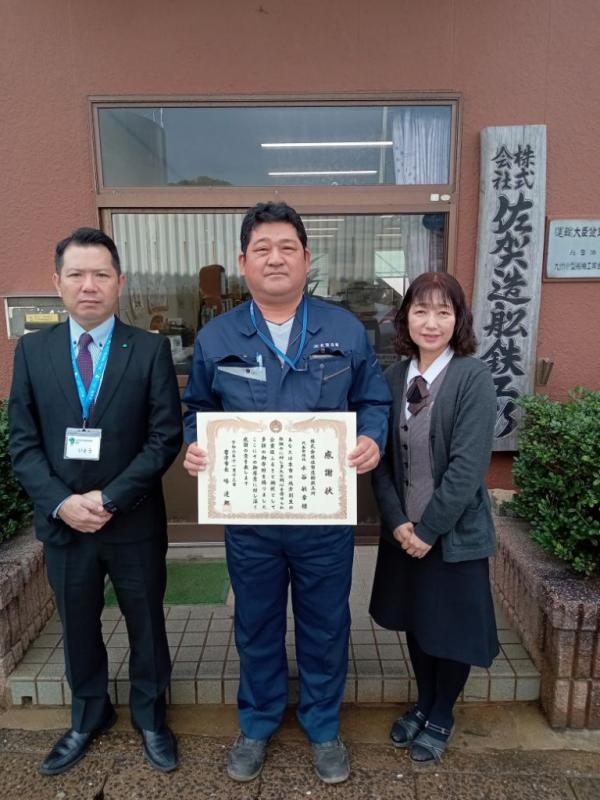 感謝状を持つ代表取締役を中央に撮影した写真