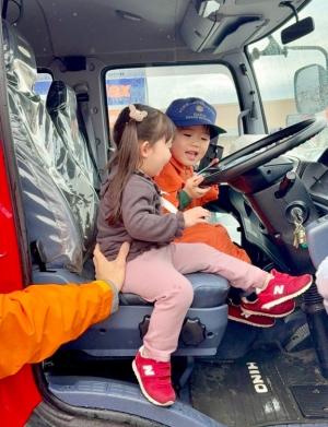 子供が消防車に乗っている写真